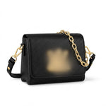 textured leather crossbody bag with a gold chain strap and gold