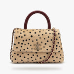 A structured handbag with a beige fur