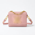 textured leather crossbody bag with a gold chain strap and gold