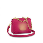 textured leather crossbody bag with a gold chain strap and gold